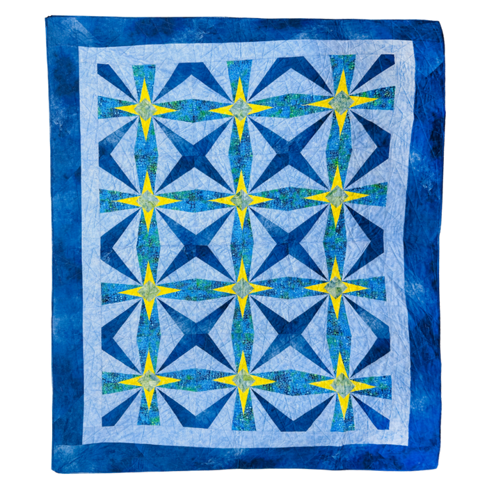 A square quilt with a geometric starburst pattern, featuring shades of blue, navy, and yellow on a white background with a blue border.